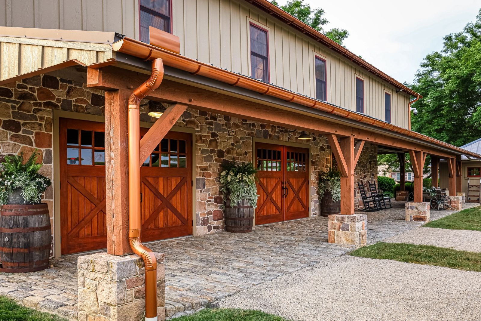 Stone and timber exterior of Koin-O-Nia Place with wooden barn doors and planters