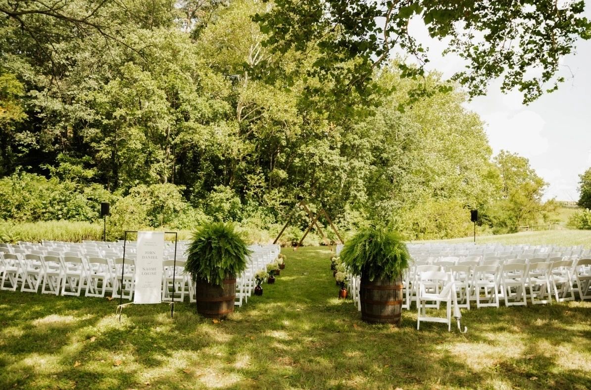 Outdoor ceremony seating set in white chairs on the lawn at Koin-O-Nia Place