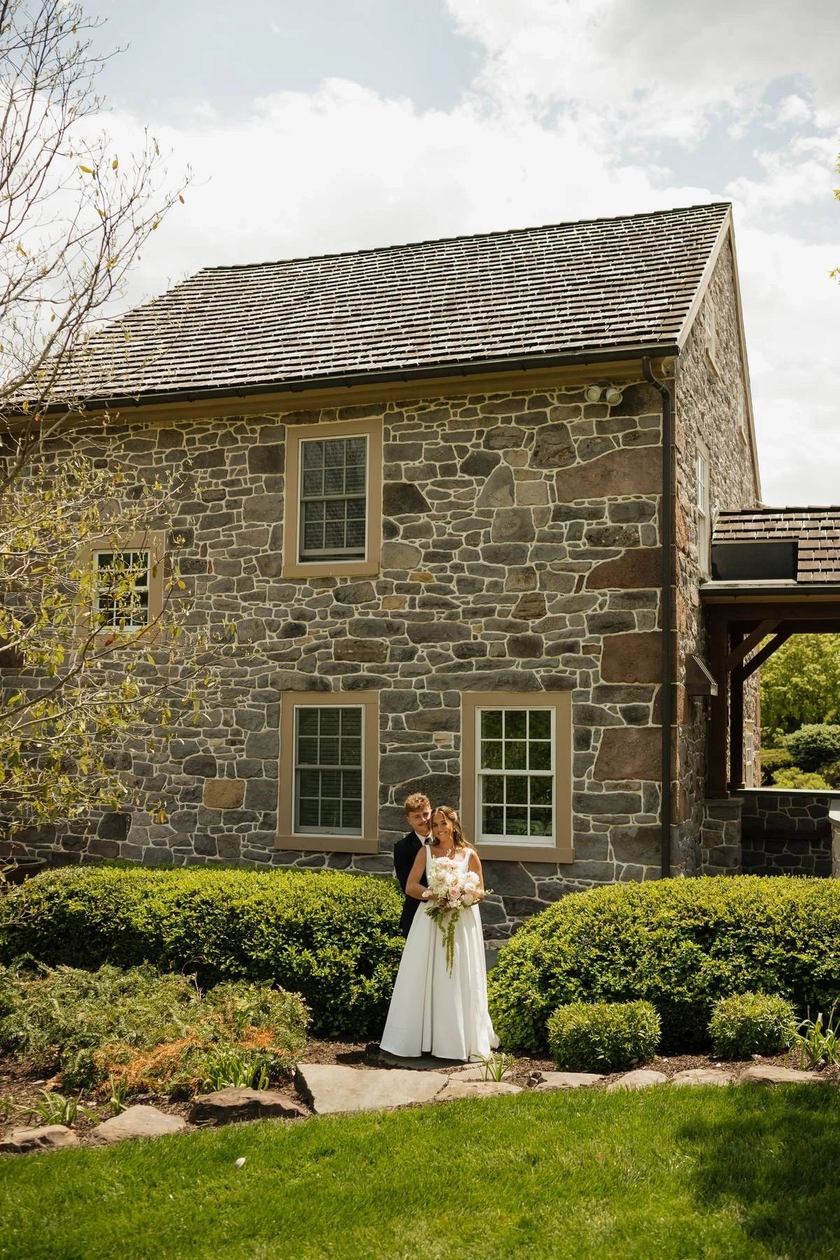 Bride and groom outside the stone farmhouse at Koin-O-Nia Place