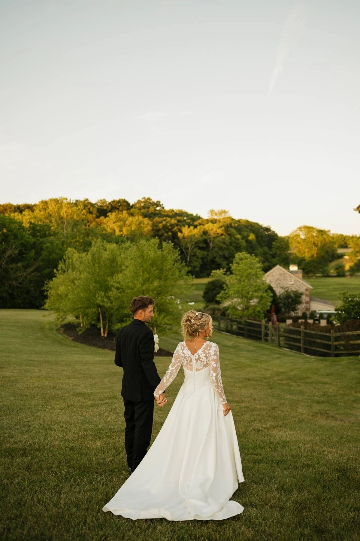 Couple holding hands in the open field at golden hour