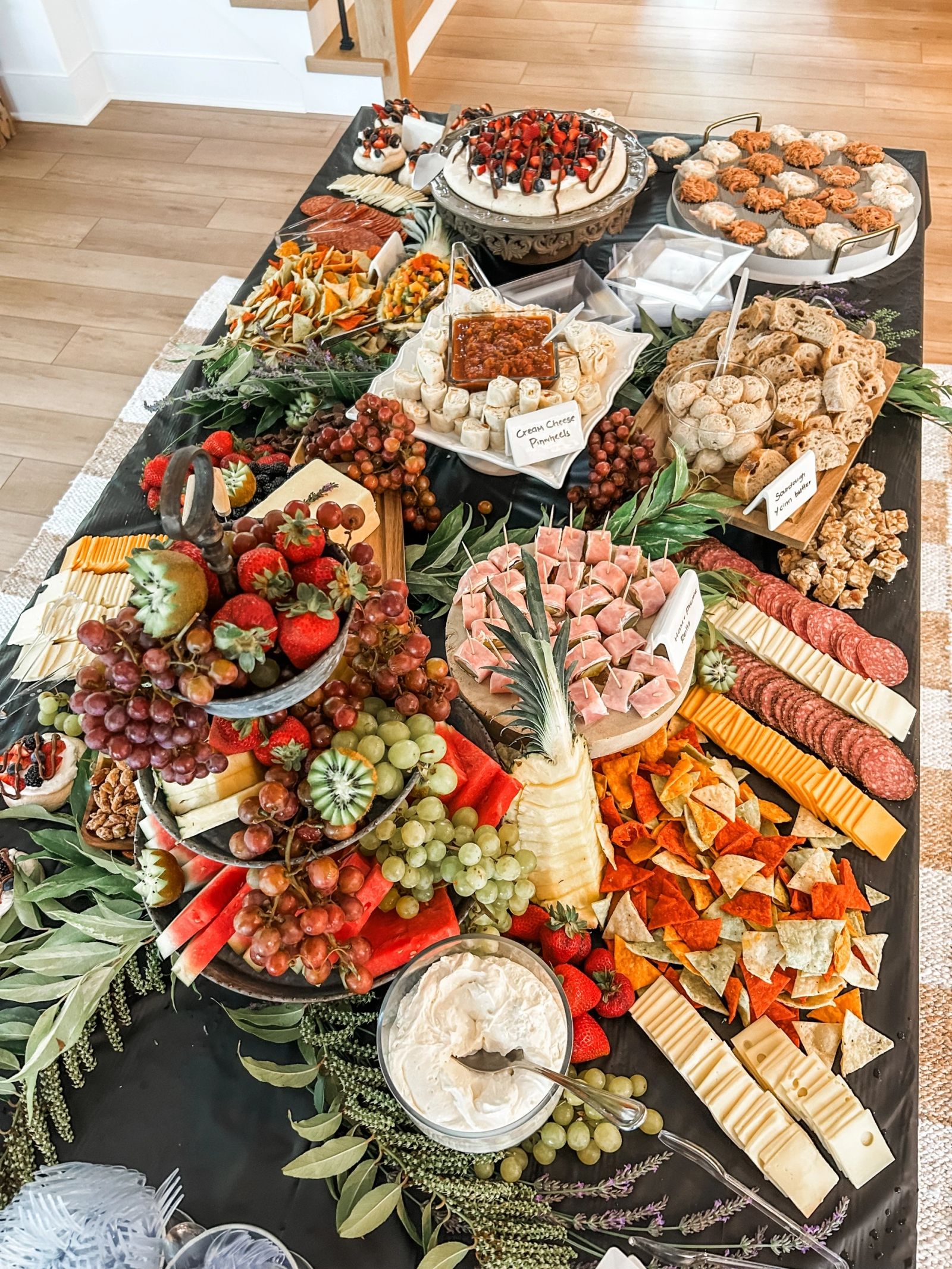 Large charcuterie and fruit grazing table with cheeses, meats and dips for an event